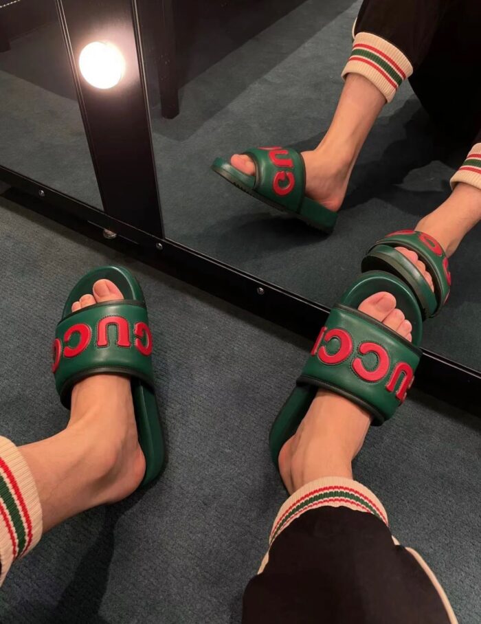 Sandali Gucci verdi e rossi riflessi in specchio, stile casual e di lusso.