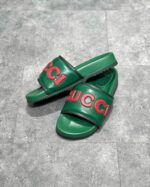 Sandali Gucci verdi con logo rosso, stile estivo, comfort e look elegante e casual.