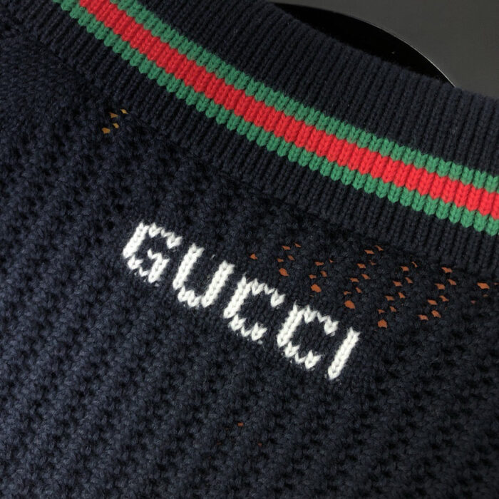 Maglione nero Gucci con colletto a strisce verde e rosso e logo ricamato frontale.