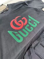 Maglietta nera con logo Gucci colorato, stile moderno e casual, perfetta per un look trendy.