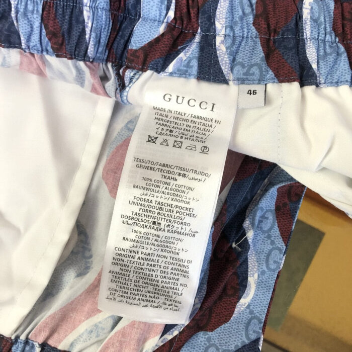 Dettaglio di abbigliamento Gucci con design colorato e etichetta di lusso elegante.