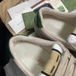 Sneaker Gucci crema con dettagli verdi, packaging di lusso e accessori di alta qualità.