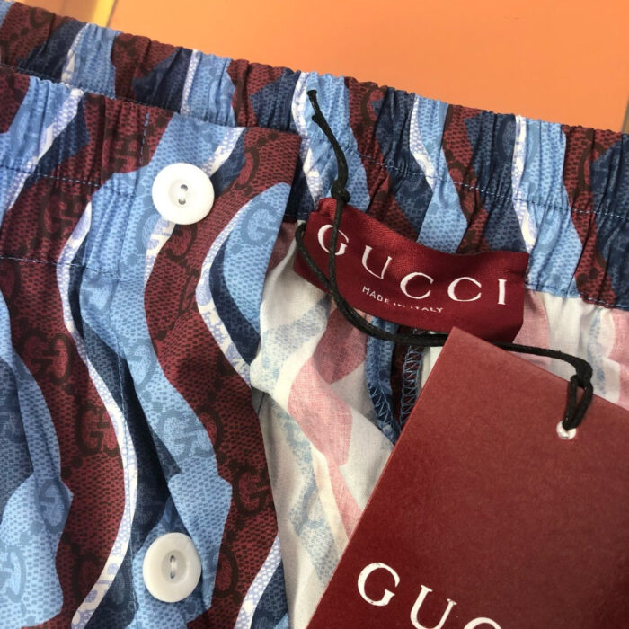 Shorts da mare Gucci con pattern vibrante di onde, logo e dettagli di alta qualità.
