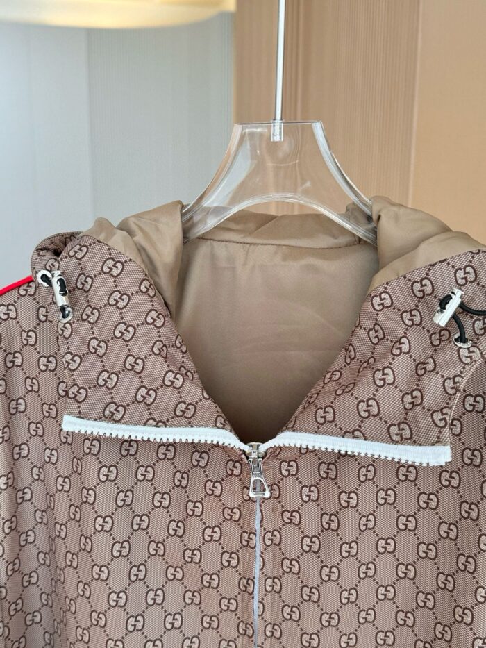 Giaccone Gucci marrone con logo doppio G, cappuccio e dettagli rossi, stile elegante e pratico.