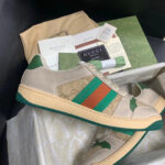 Sneaker Gucci beige con strisce verde e arancione, stile elegante e di lusso urbano.