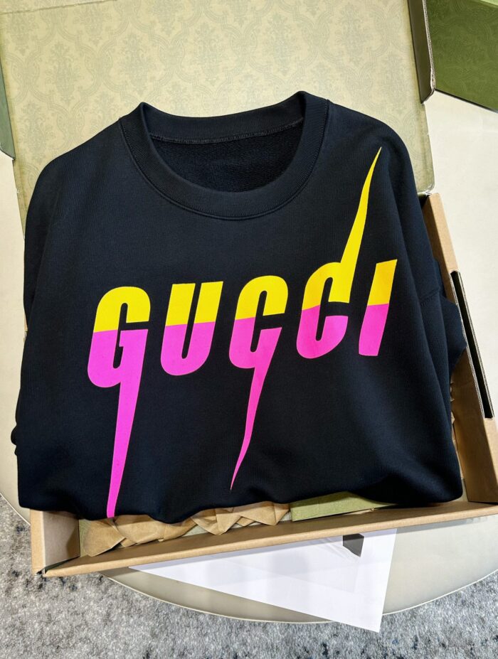 Maglietta Gucci nera con design colorato, scoperta in scatola, stile streetwear trendy.