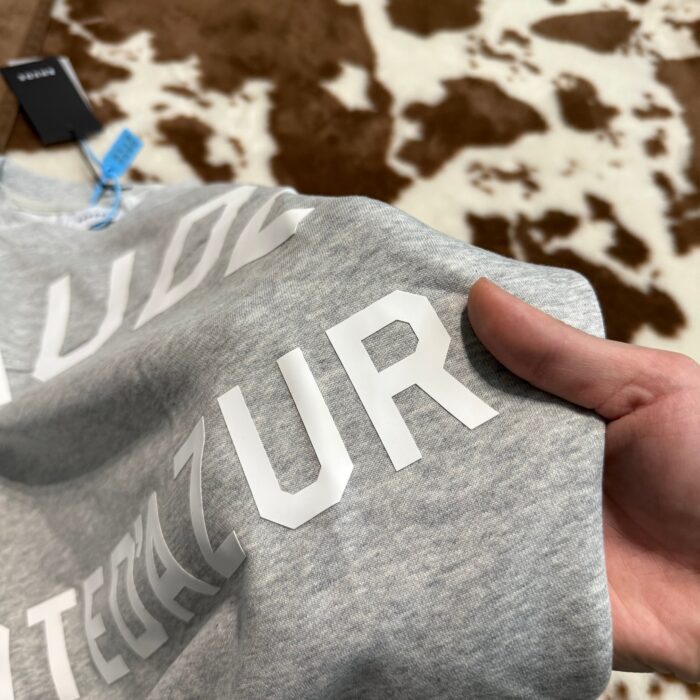 Felpa grigia con logo bianco INTEGRAL AZUR, stile streetwear, tag retail visibile.