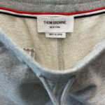 Etichetta di lusso Thom Browne con dettagli signature e produzione Made in Japan.