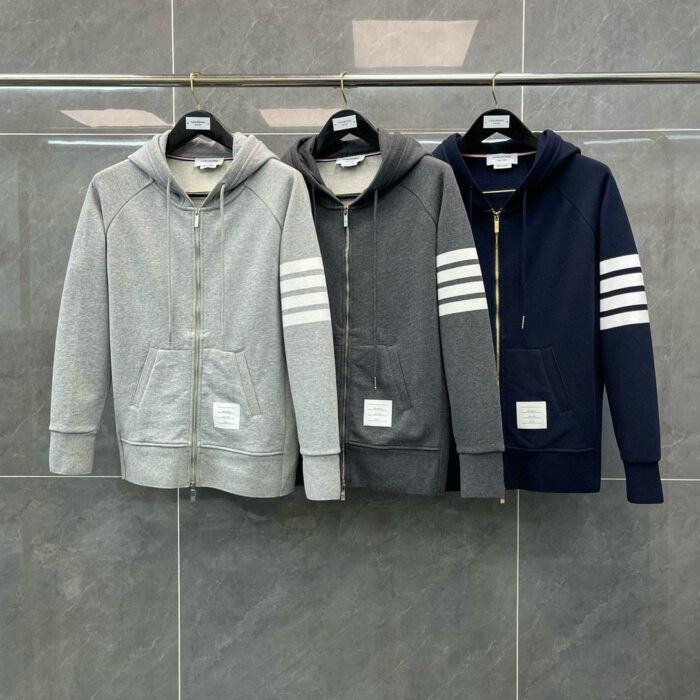 Tre felpe con zip e strisce sportive in grigio e navy, stile casual e alla moda.