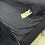 Interno di giacca nera con fodera liscia, etichetta e zip resistente.
