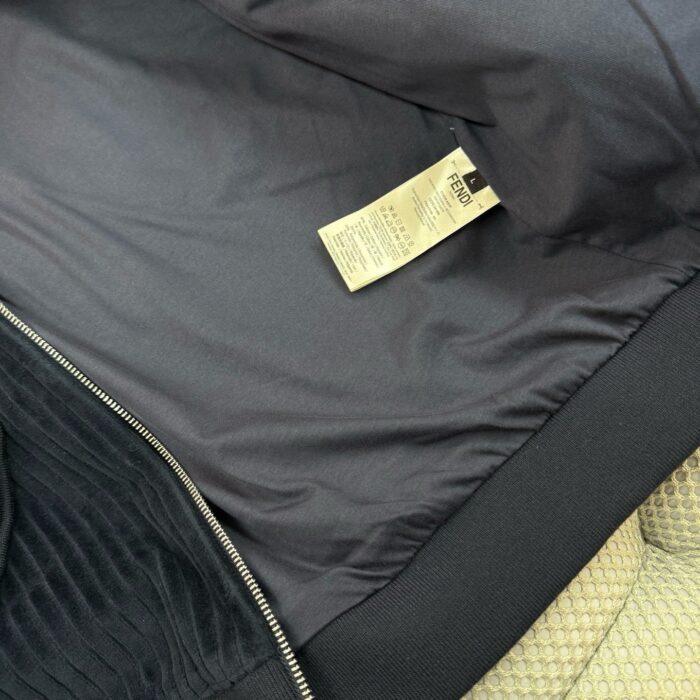 Interno di giacca nera con fodera liscia, etichetta e zip resistente.