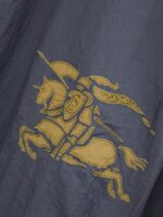 Emblema ricamato di cavaliere medievale in oro su sfondo blu navy.