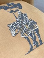 Cavaliere eraldico con scudo, bandiera e cavallo in design storico e moderno su tessuto caldo.