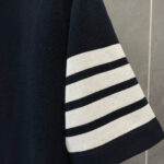 Manica di camicia navy con strisce bianche orizzontali, stile nautico e dettagli curati.