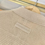 Maglione beige in maglia con collo a coste e dettaglio a loop, stile casual e elegante.