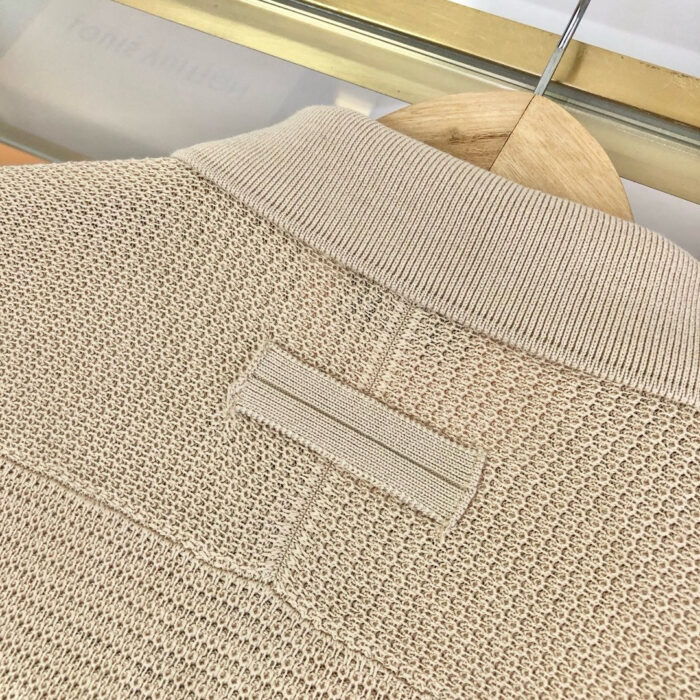 Maglione beige in maglia con collo a coste e dettaglio a loop, stile casual e elegante.