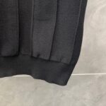 Dettaglio dell’orlo a costina di un pullover nero in maglia tessuta, moda casual elegante.