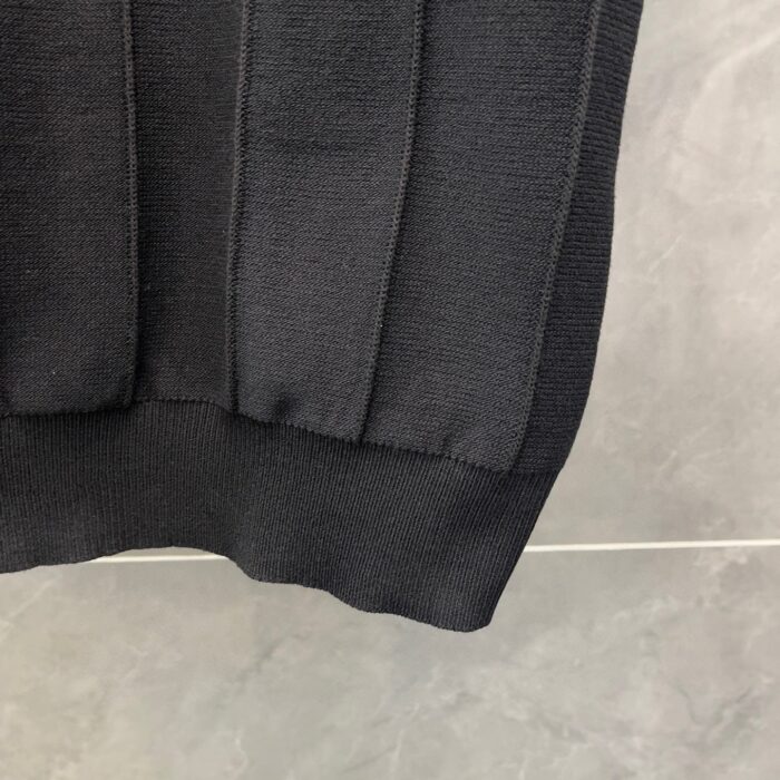 Dettaglio dell’orlo a costina di un pullover nero in maglia tessuta, moda casual elegante.