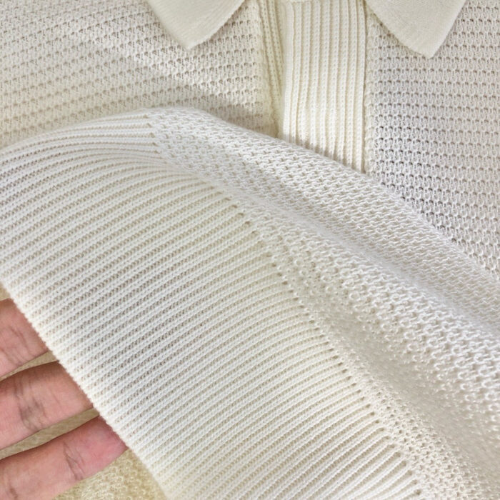 Maglietta polo in maglia color crema, dettaglio tessuto e collo elegante, ideale per look casual e raffinati.