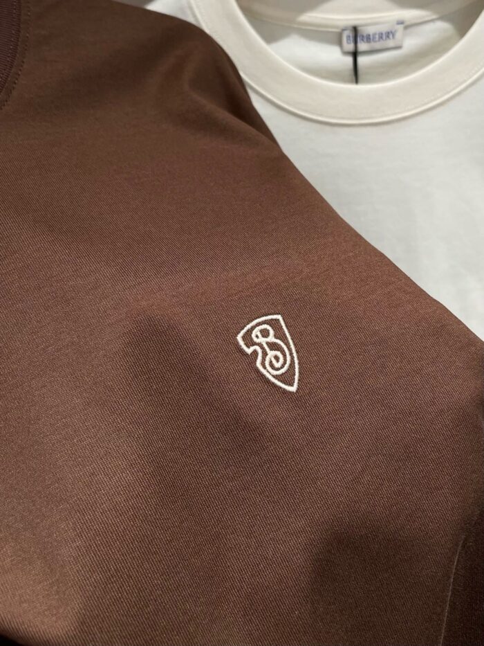 Magliette casual a strati bianco e marrone con logo ricamato, stile trendy e versatile.