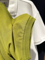 Maglione verde a maglia e polo bianca: outfit casual, versatile e di stile.