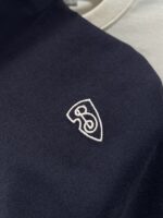 Polo navy e beige stratificate con logo ricamato, stile elegante e casual per uomo.