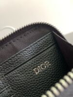 Portafoglio nero in pelle con logo dorato e chiusura lampo elegante.