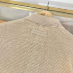 Giaccone beige in lana con colletto minimalista e dettagli discreti, ideale per un look elegante e casual.