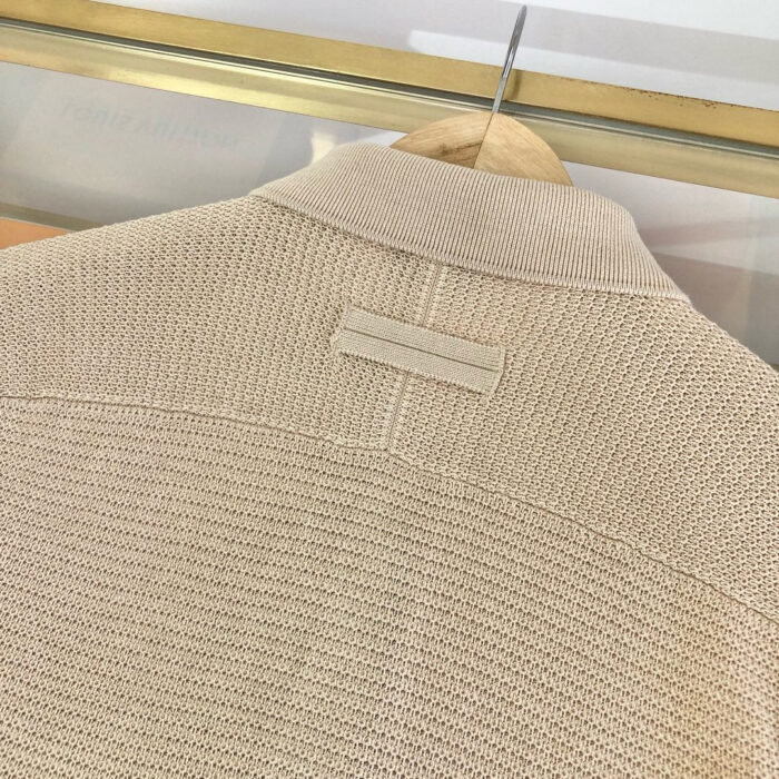 Giaccone beige in lana con colletto minimalista e dettagli discreti, ideale per un look elegante e casual.