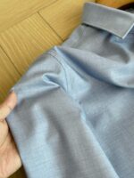 Camicia blu chiaro elegante in tessuto morbido, dettagli curati, stile casual e sofisticato.