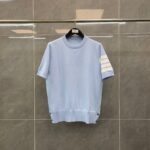 Maglione blu chiaro casual con bottoni e dettaglio a strisce, perfetto per look estivi e sportivi.