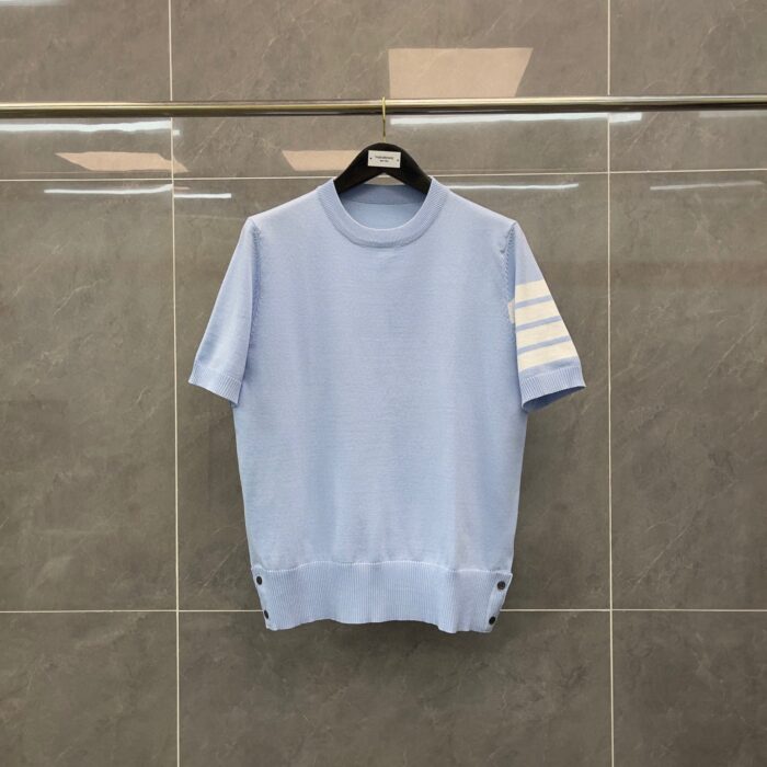 Maglione blu chiaro casual con bottoni e dettaglio a strisce, perfetto per look estivi e sportivi.