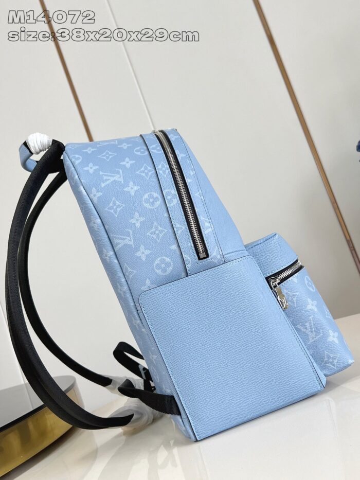 Zaino blu elegante in materiale opaco con zip moderne e spallacci regolabili.