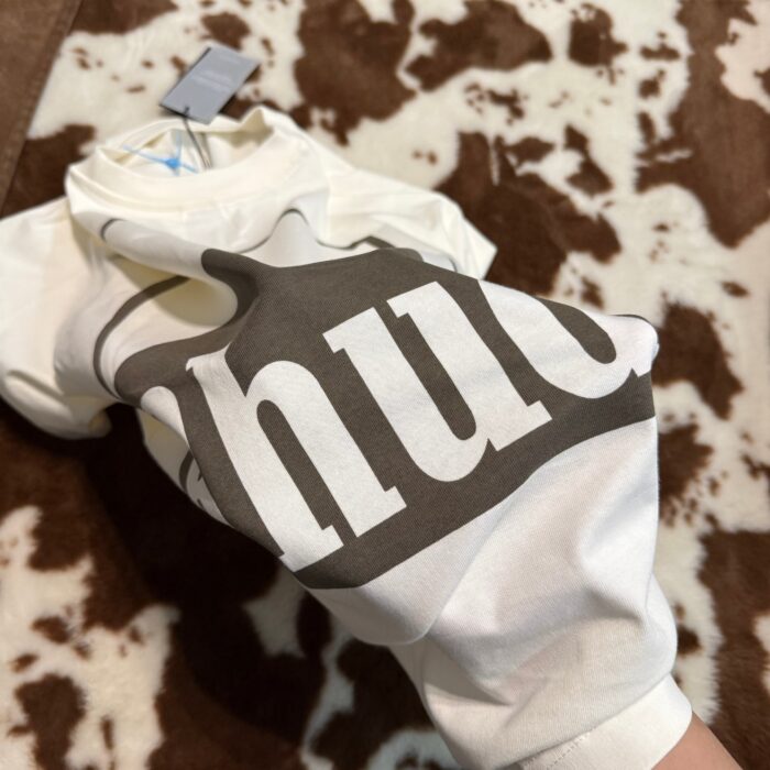 T-shirt bianco con scritta huh in stile casual, morbido tessuto, sfondo in pelliccia animalier.