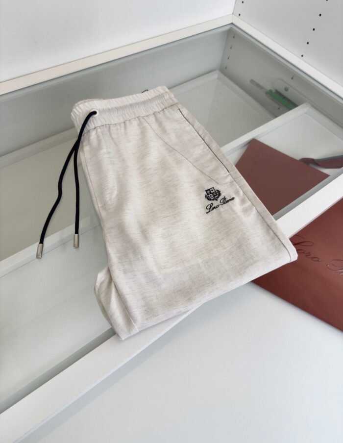 Pantaloni sportivi chiari con vita regolabile e logo discreto, perfetti per look casual ed eleganti.