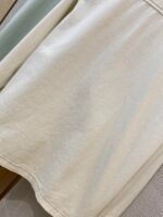 Tessuto beige leggero con trama sottile, ideale per abbigliamento e decorazioni eleganti.