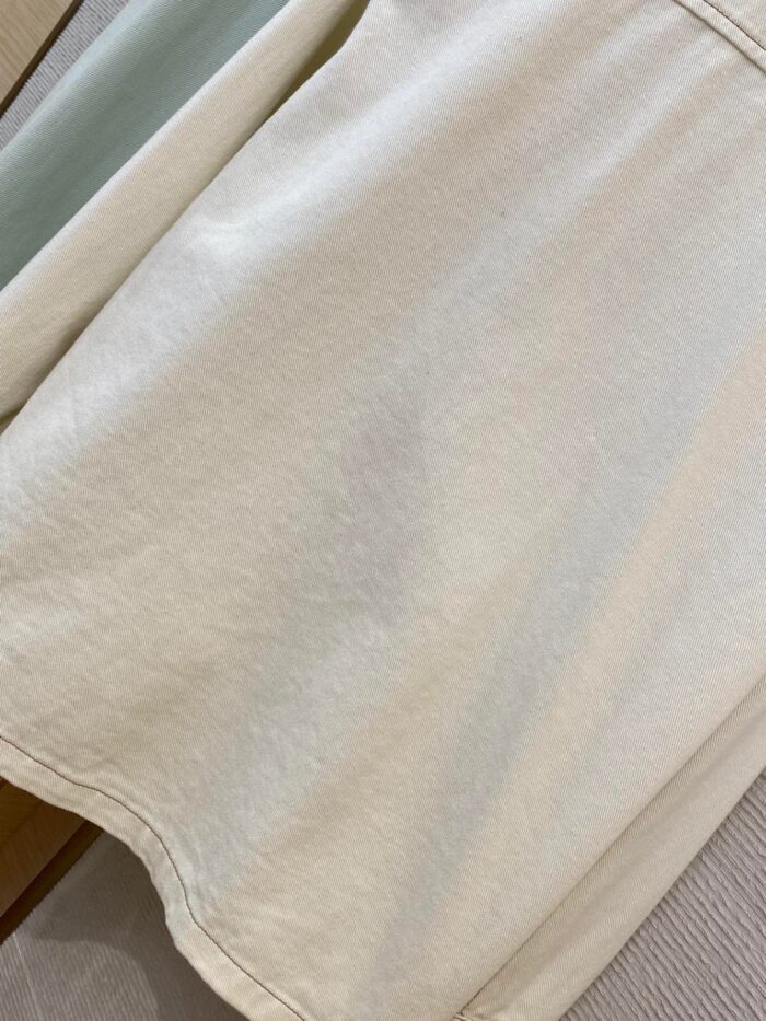 Tessuto beige leggero con trama sottile, ideale per abbigliamento e decorazioni eleganti.