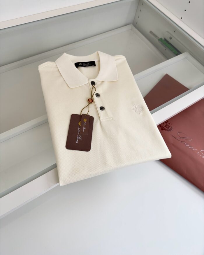 Camicia polo crema in esposizione, elegante e versatile, con dettaglio ricamato e etichetta in vista.