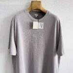 T-shirt grigia chiara minimalista con logo embossato, in cotone morbido, eleganza discreta.