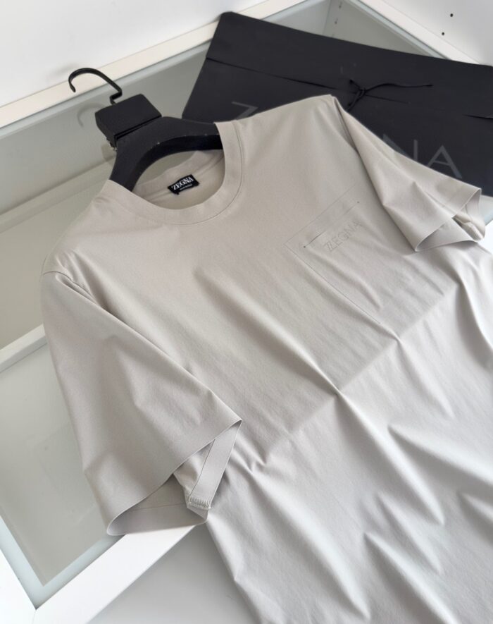 T-shirt grigia minimalista in cotone con tasca, stile moderno e versatile per ogni occasione.