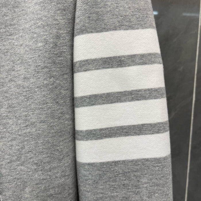 Top casual grigia con strisce sportive, stile vintage e comfort versatile.