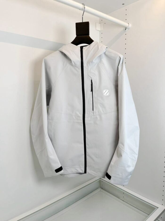 Giacca grigia impermeabile moderna da esterni, leggera e versatile con cappuccio e tasca zip.