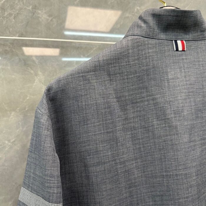 Camicia grigia elegante con dettaglio tricolore sul colletto e soffice tessuto texture.