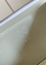 Portafoglio verde chiaro con zip e logo embossato, materiali di alta qualità e design elegante.