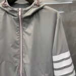 Giacchetto grigio leggero sportivo con cappuccio e dettagli a strisce bianche, versatile e moderno.