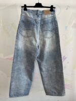 Jeans chiari a vestibilità comoda, stile casual, su sfondo colorato e creativo.