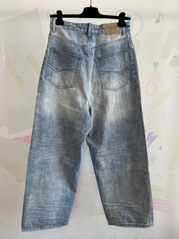 Jeans chiari a vestibilità comoda, stile casual, su sfondo colorato e creativo.