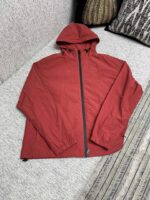 Giacca rossa leggera con cappuccio, stile casual e pratico per outdoor e giornate breezy.