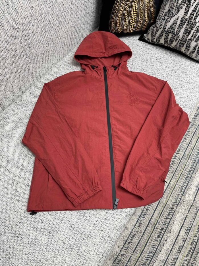 Giacca rossa leggera con cappuccio, stile casual e pratico per outdoor e giornate breezy.