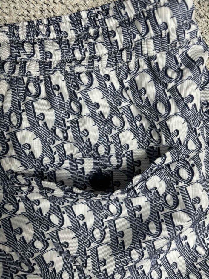 Shorts bianchi elasticizzati con motivo blu e logo, perfetti per uno stile casual estivo e trendy.